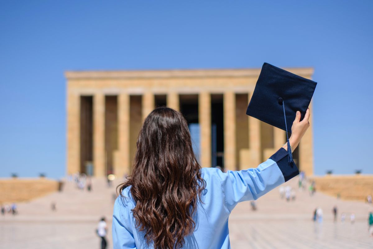 A graduate raising their cap