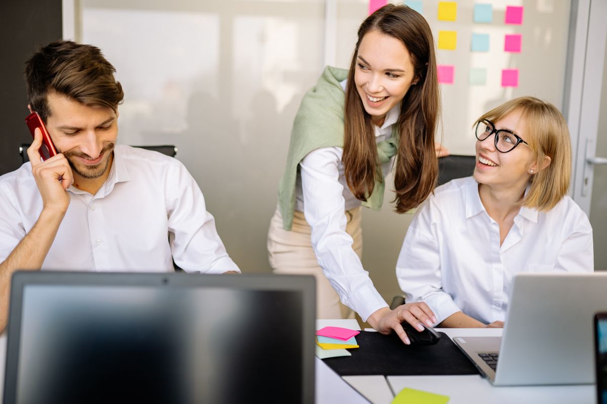 A mentor coaching a colleague at a desk