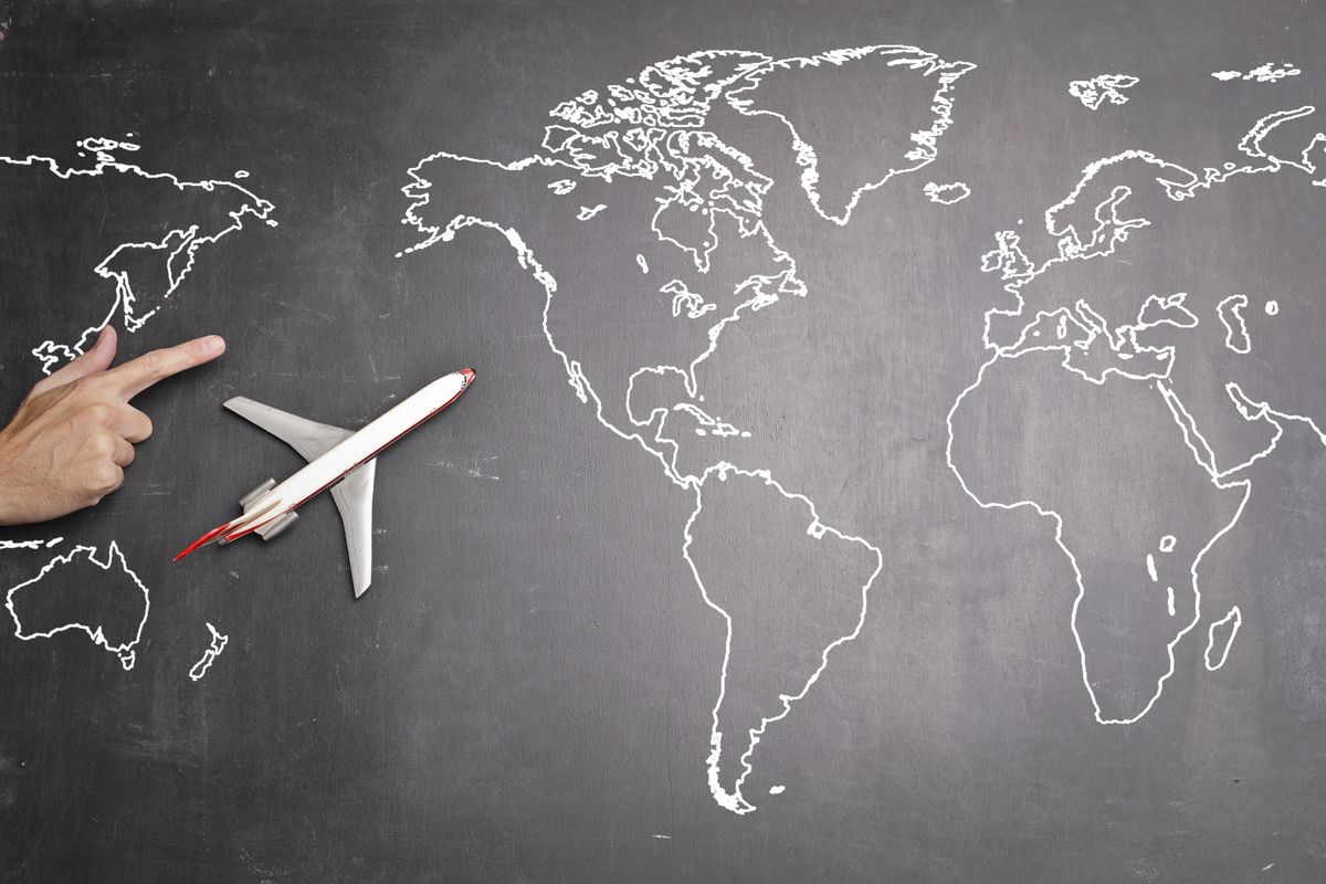 A model plane on a chalk-drawn world map